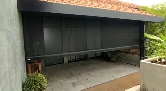 Motorized outdoor screen across a patio